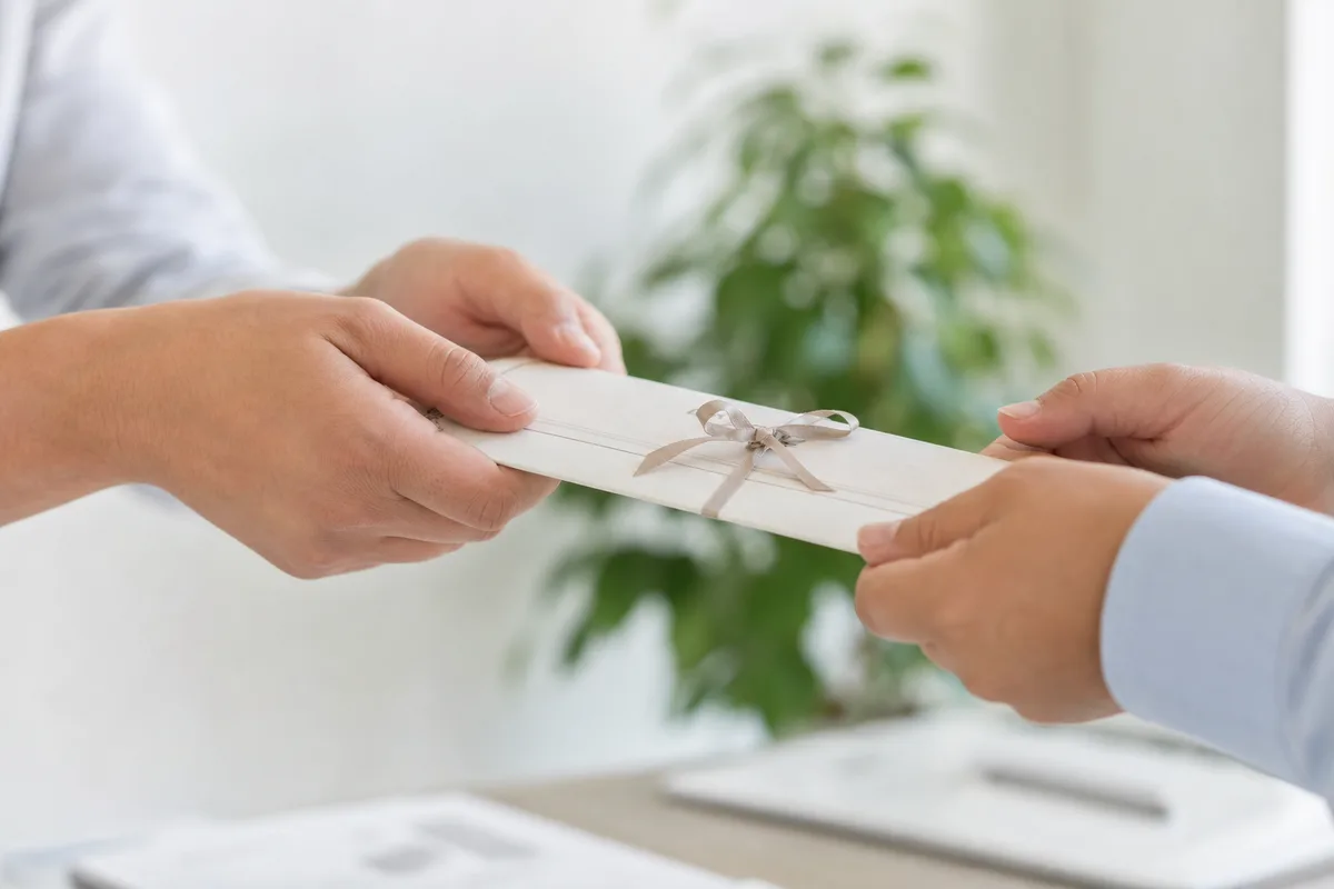 Remise d&rsquo;un certificat professionnel entre deux personnes dans un bureau lumineux